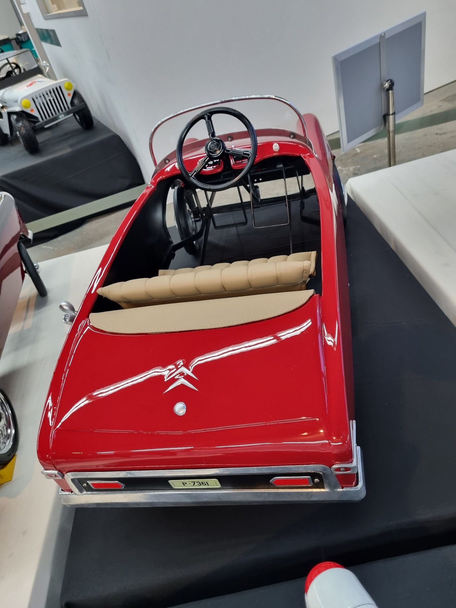 Ein rotes Spielzeugauto mit Lenkrad ist ausgestellt